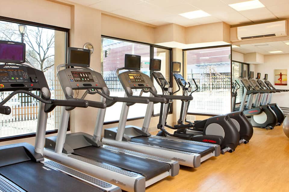 Fitness center with treadmills and exercise equipment near large windows