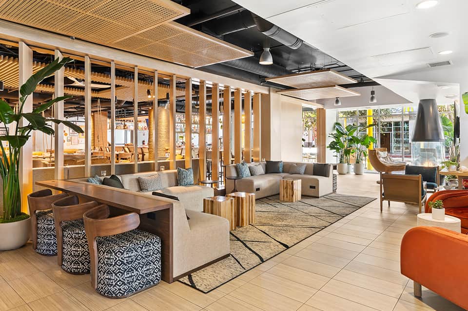 Contemporary resort lobby with wooden partitions, lounge seating, and natural light