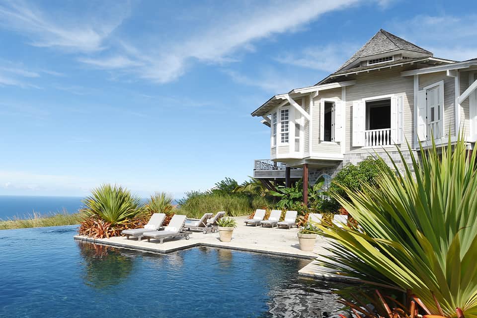 Luxury beachfront house with infinity pool, ocean view, and white modern architecture