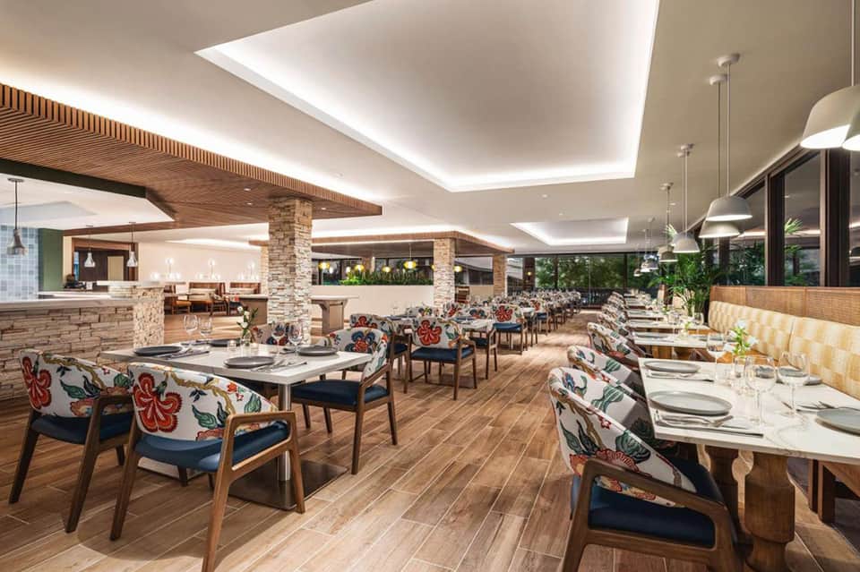Contemporary hotel restaurant with colorful chairs, wooden accents, and skylights