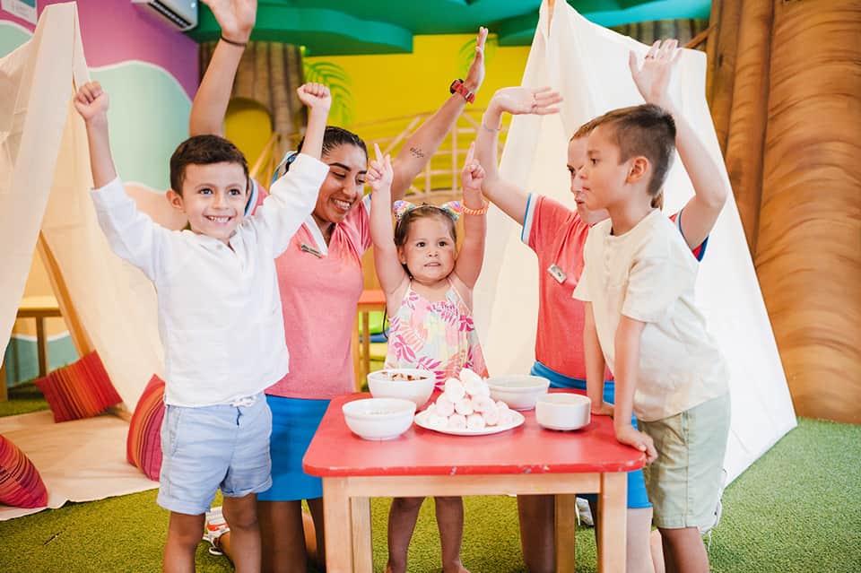 Children and staff celebrating indoors at kids club activity area