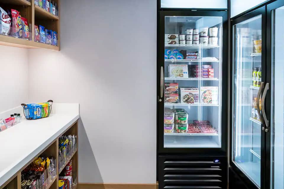Hotel convenience store with refrigerated cases stocked with snacks and beverages