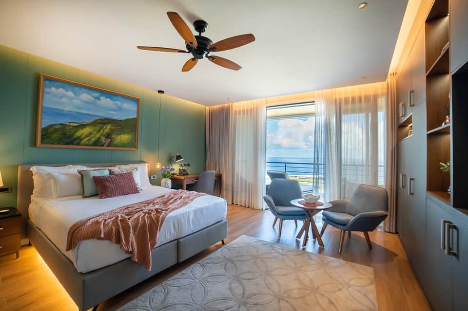 Luxury oceanview bedroom with turquoise walls, ocean view balcony, and modern furnishings