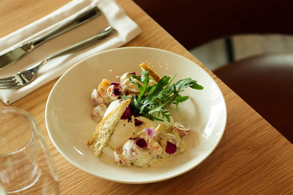 Artfully plated fine dining dish with garnish, edible flowers, and elegant presentation