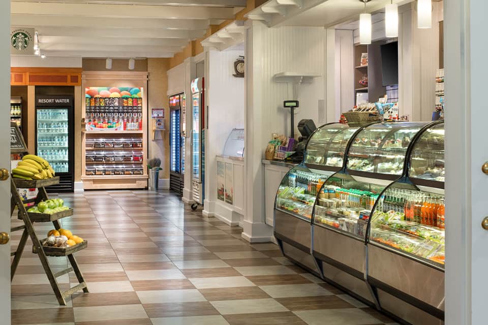 Resort convenience store with refrigerated cases, vending machines, fresh produce, and Starbucks logo visible