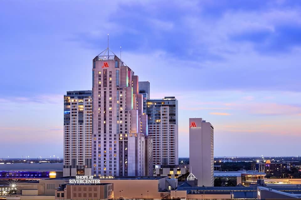 Downtown skyline at dusk with illuminated high-rise buildings and river view