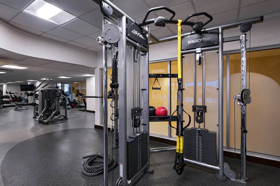 Modern fitness center with Synergy360 equipment, cable machines, and mirrored walls