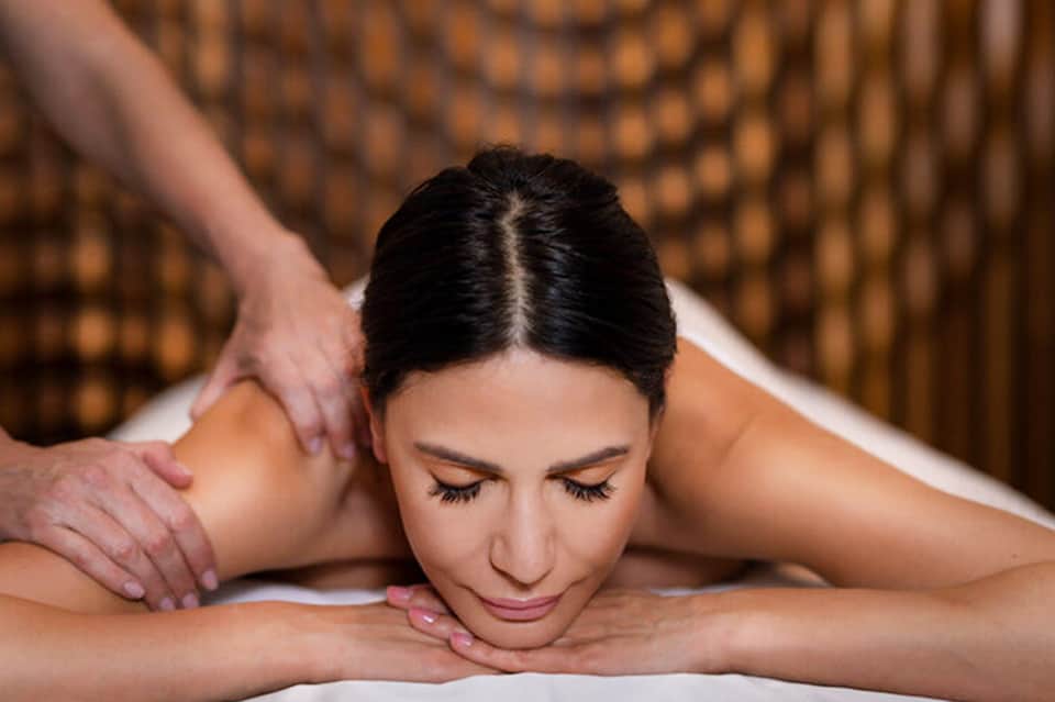 Woman receiving a relaxing back massage at a spa with warm lighting