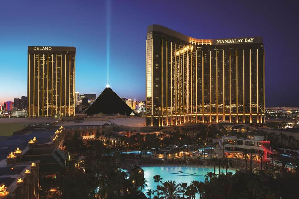 Mandalay Bay and Delano hotels illuminated at dusk with pyramid structure and pool area in Las Vegas