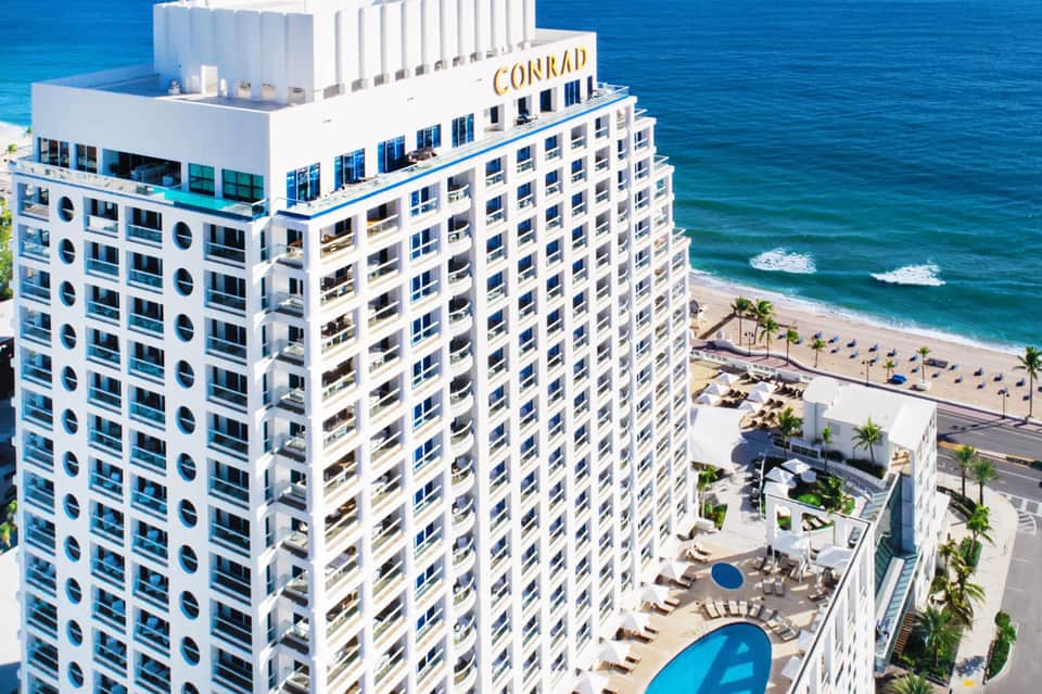 Conrad hotel high-rise tower overlooking beach with blue ocean and sand