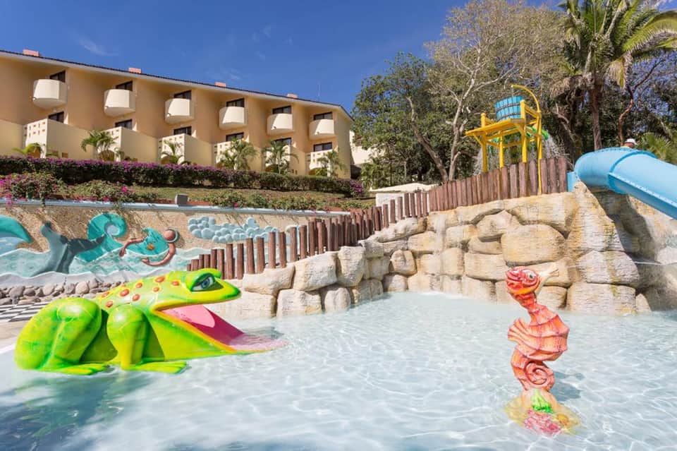 Colorful shallow water pool area with green crocodile float and coral seahorse sculpture