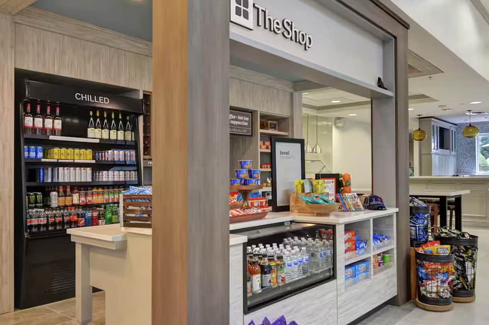 Modern convenience shop interior with chilled beverage cooler and snacks counter