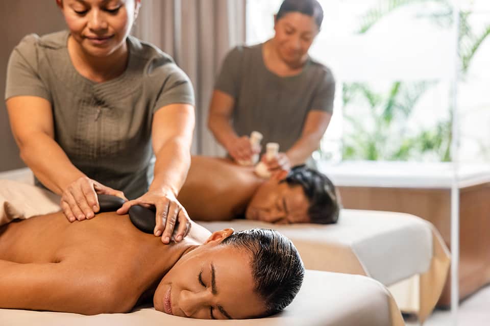 Spa therapists providing relaxing massages to clients on treatment beds