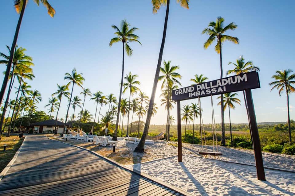 Sandy boardwalk with palm trees and Grand Palladium Meassai sign
