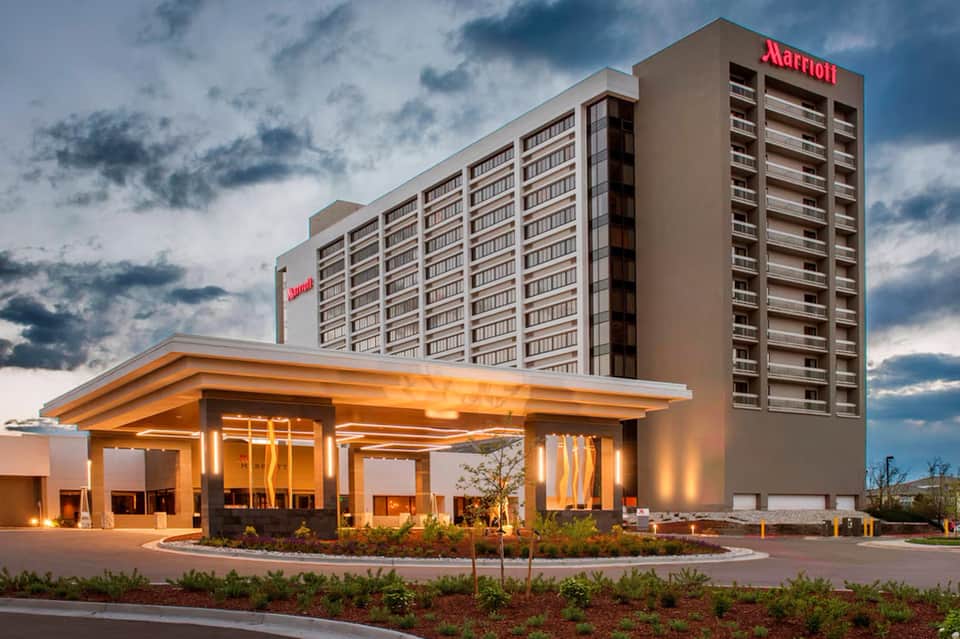 Modern Marriott hotel exterior at dusk with illuminated entrance canopy and multi-story tower building