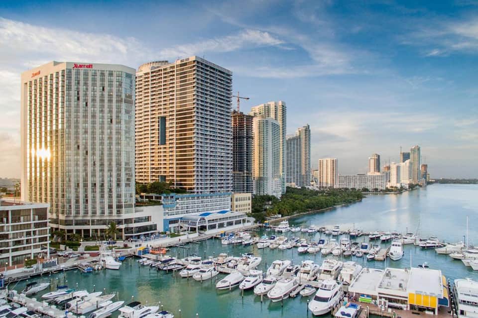 Waterfront resort with Marriott hotel, high-rise buildings, and marina filled with boats