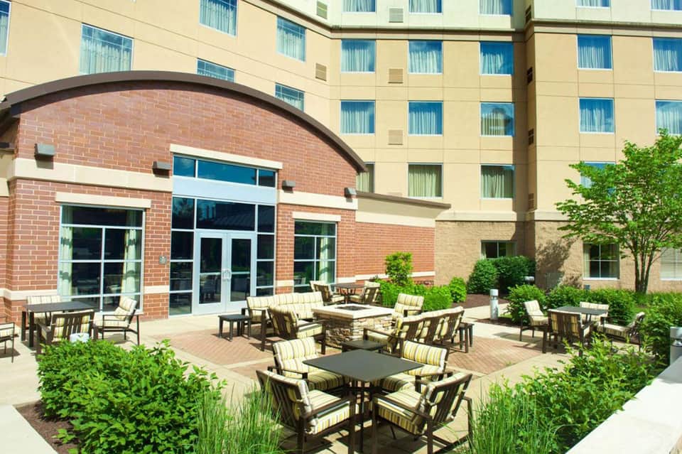 Hotel courtyard with brick architecture, fire pit seating, and manicured landscaping