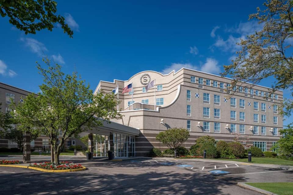 Brick hotel exterior with distinctive curved architectural roof and manicured landscaping