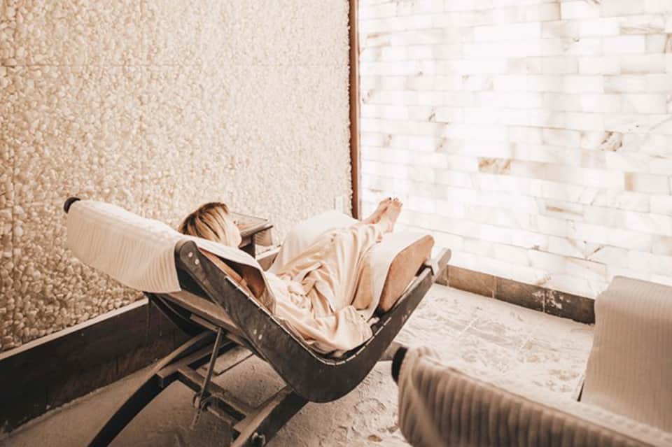Person relaxing in lounge chair in minimalist brick-walled interior space