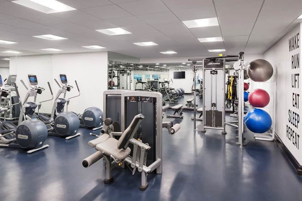 Modern fitness center with cardio equipment, weight machines, and exercise balls