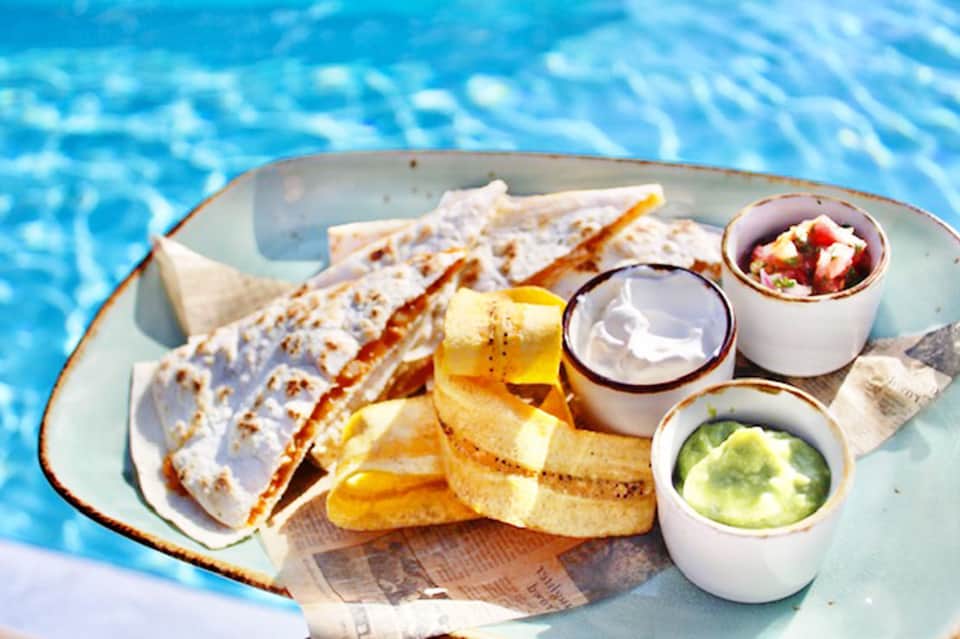 Fish tacos with crispy fries and three dipping sauces served poolside