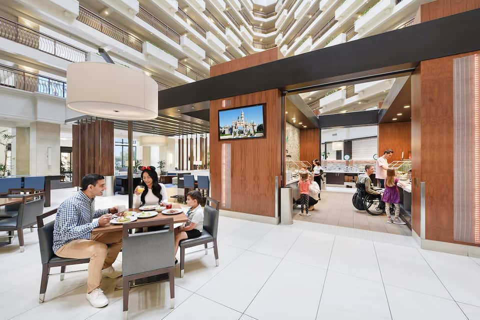 Contemporary hotel lobby and dining area with family enjoying meal, modern ceiling design, and open floor plan