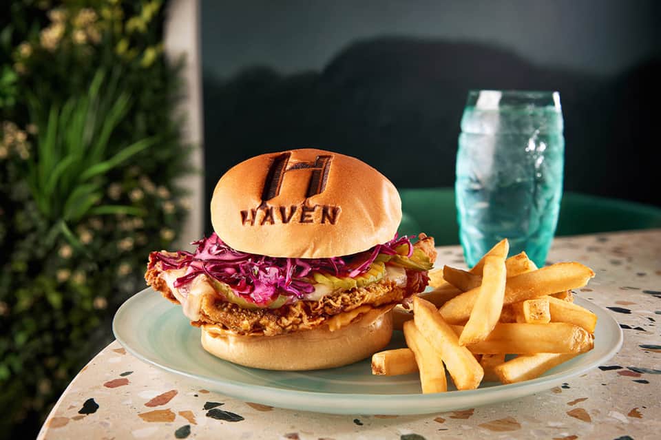 Crispy fried chicken sandwich with red cabbage slaw and golden fries served at Haven restaurant