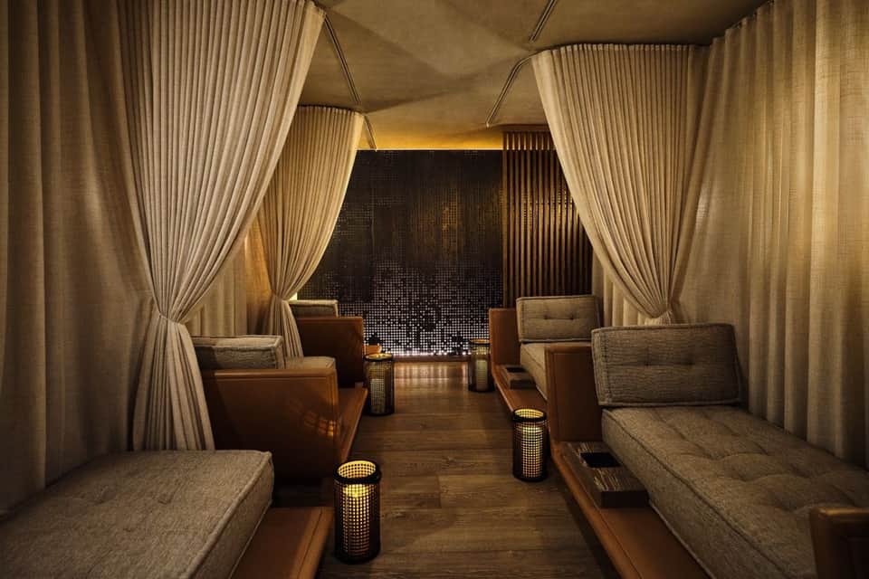 Elegant spa relaxation lounge with cream curtains, ambient lighting, and plush seating