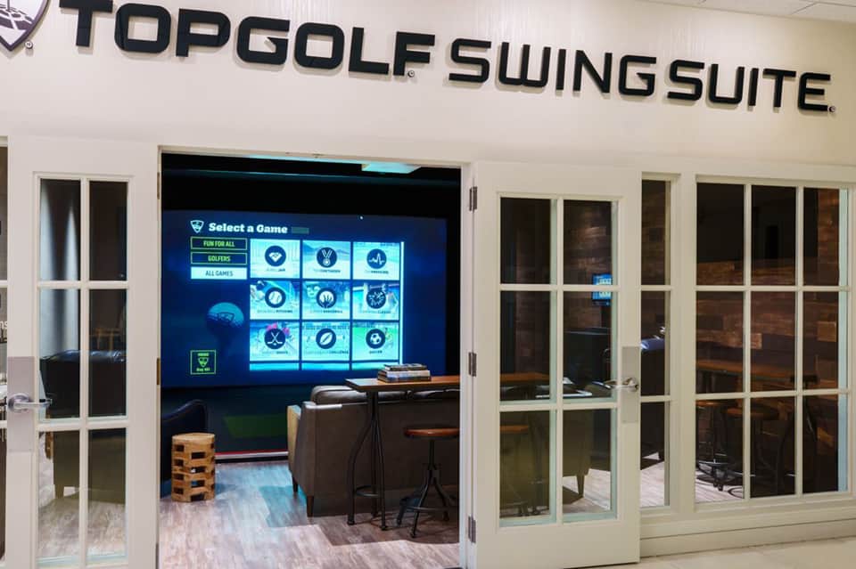 TopGolf Swing Suite entrance with interactive golf game screen displaying game selection menu