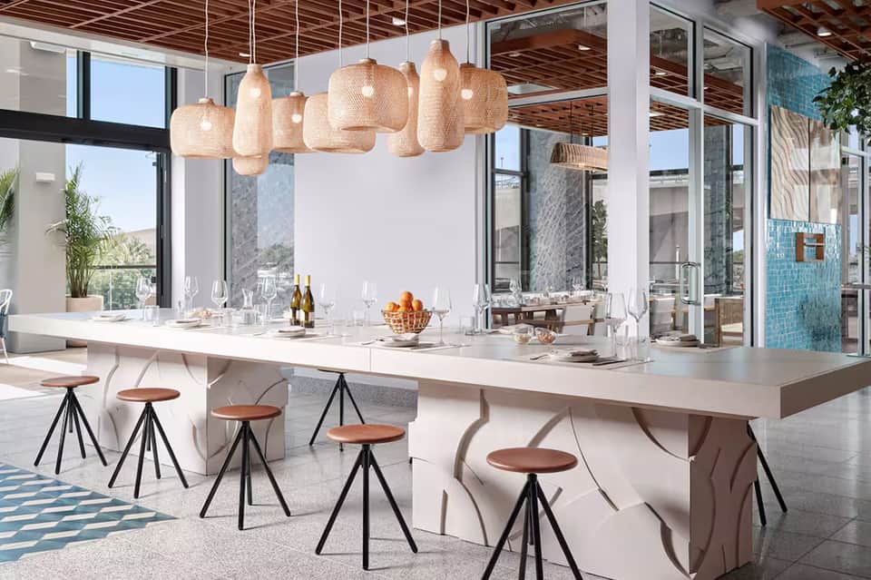 Upscale dining area with woven pendant lights and waterfront views