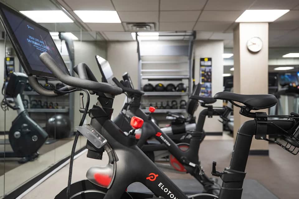 Modern fitness studio with stationary bikes and exercise equipment under bright ceiling lights