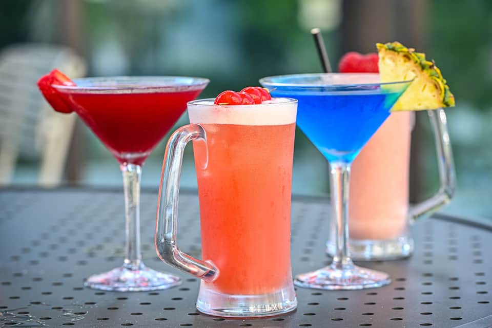 Colorful cocktails with tropical garnishes on outdoor bar table