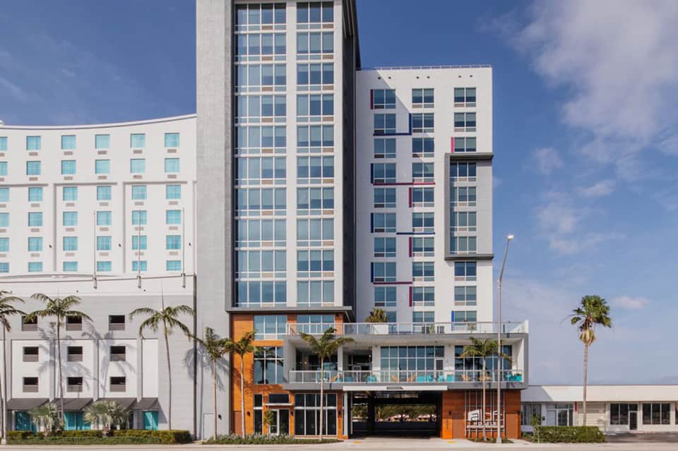 Modern beachfront hotel exterior with contemporary architecture and palm trees