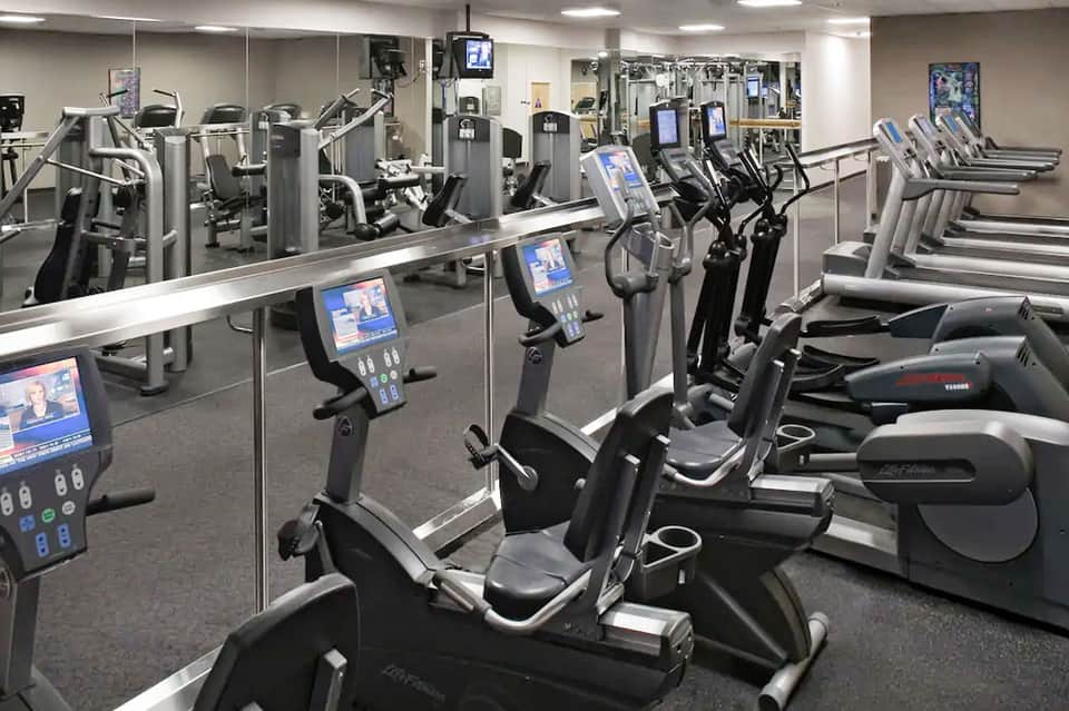 Modern fitness center with cardio equipment, stationary bikes, and mirrored walls