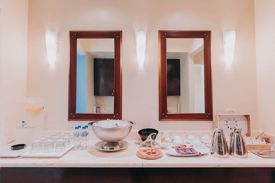 Luxury bathroom vanity with dual mirrors, marble countertop, and spa amenities