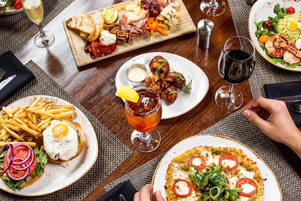 Fine dining table with gourmet dishes, wine glasses, charcuterie board, and appetizers