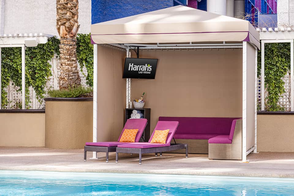 Harrahs Las Vegas poolside cabana with magenta seating and retractable awning overlooking swimming pool