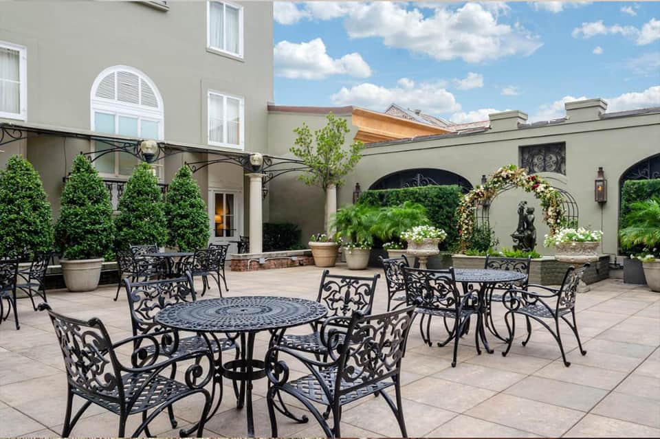 Courtyard patio with ornate black metal furniture and manicured landscaping