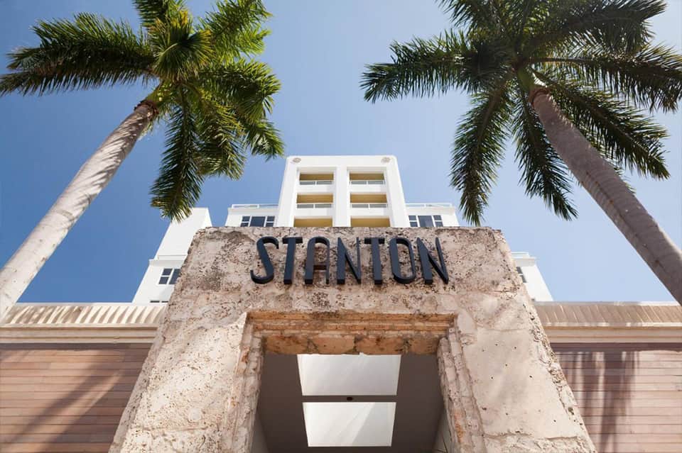 Historic Stanton building entrance with white modern architecture and palm trees against blue sky