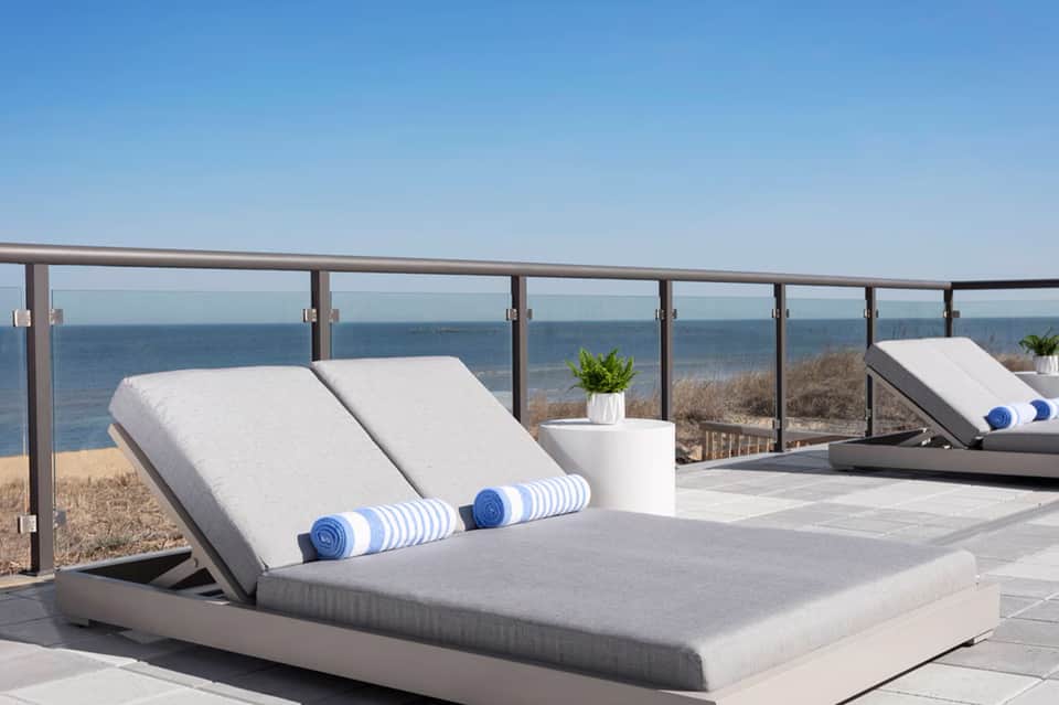 Modern lounge chairs with ocean and beach views from coastal terrace