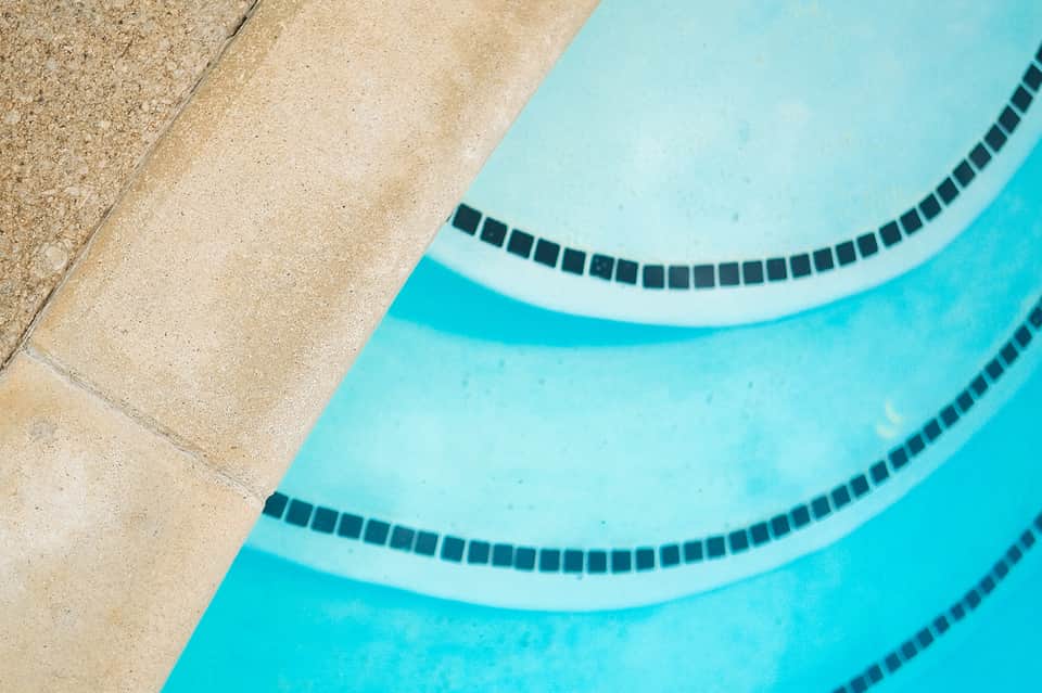 Overhead view of swimming pool with lane dividers and tan deck area