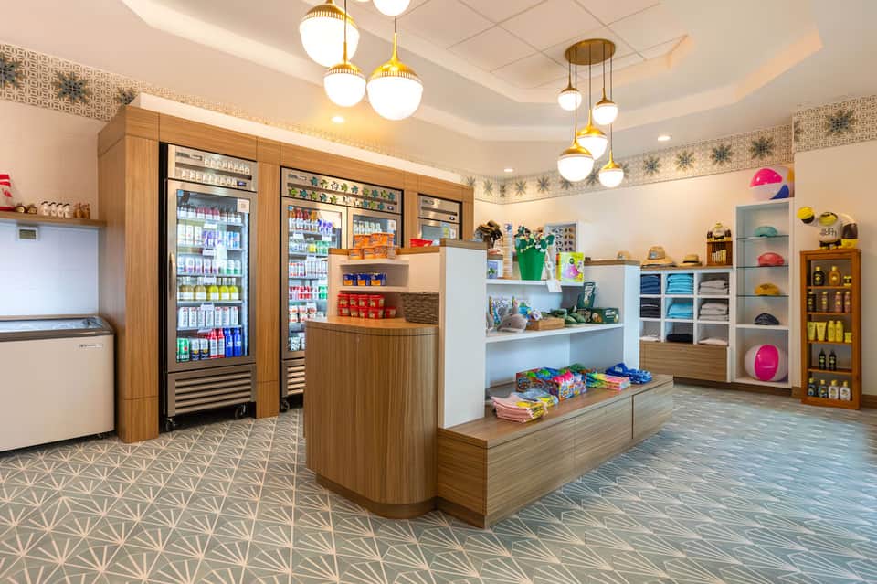 Bright retail shop interior with beverage coolers, colorful merchandise displays, and modern fixtures