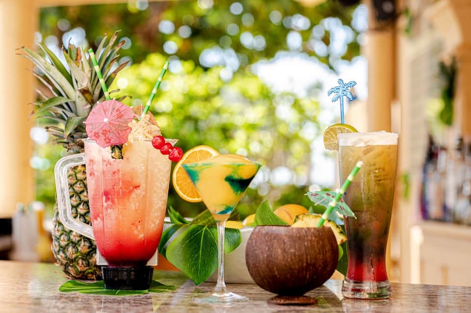 Tropical cocktails with fresh fruit garnishes and colorful drinks on a resort bar counter