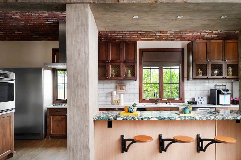 Contemporary kitchen with dark wood cabinets, white subway tile backsplash, and bar seating