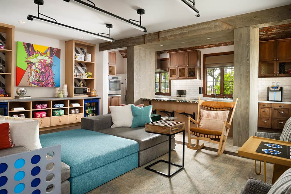 Modern playroom with turquoise sectional sofa, kitchenette, and colorful pop art