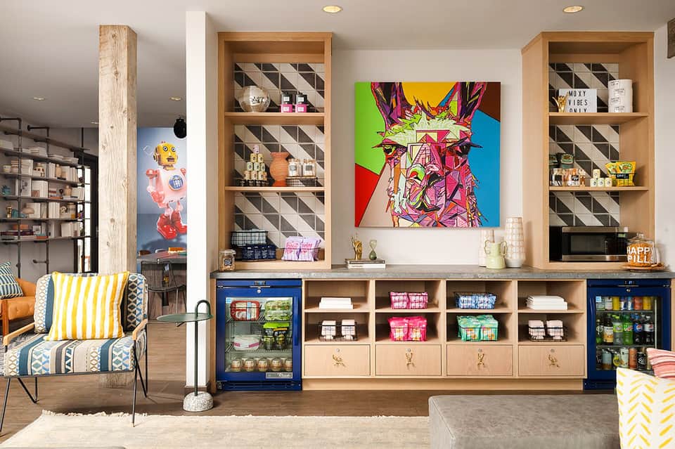 Colorful playroom with wooden shelving, pop art llama painting, patterned chair, and organized storage bins