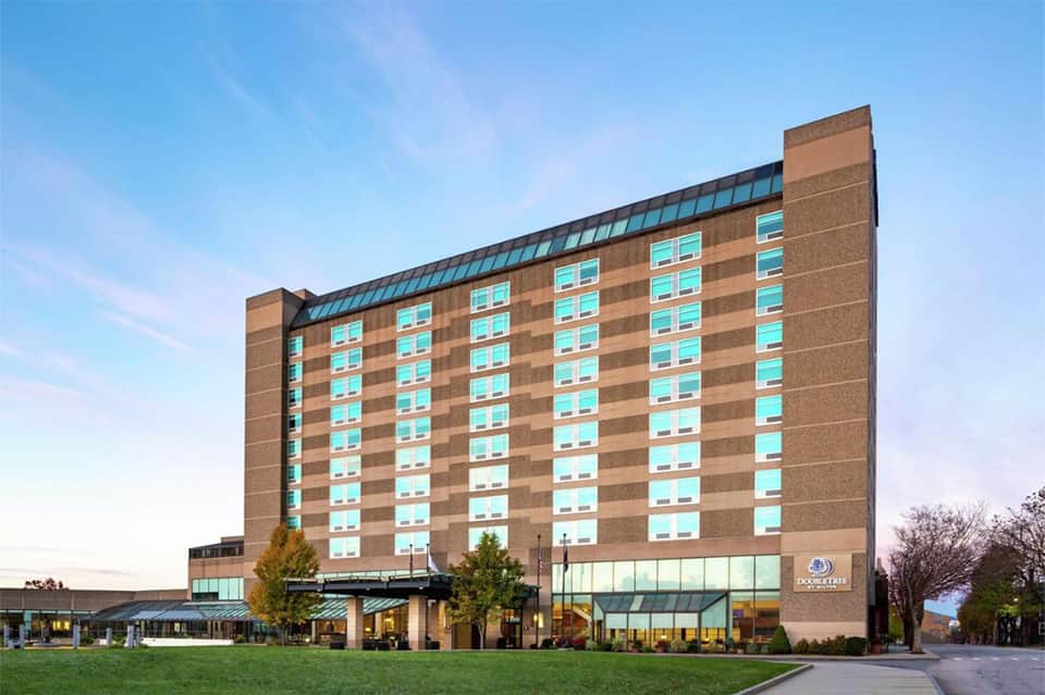 Brick hotel building with turquoise windows and modern ground-level entrance