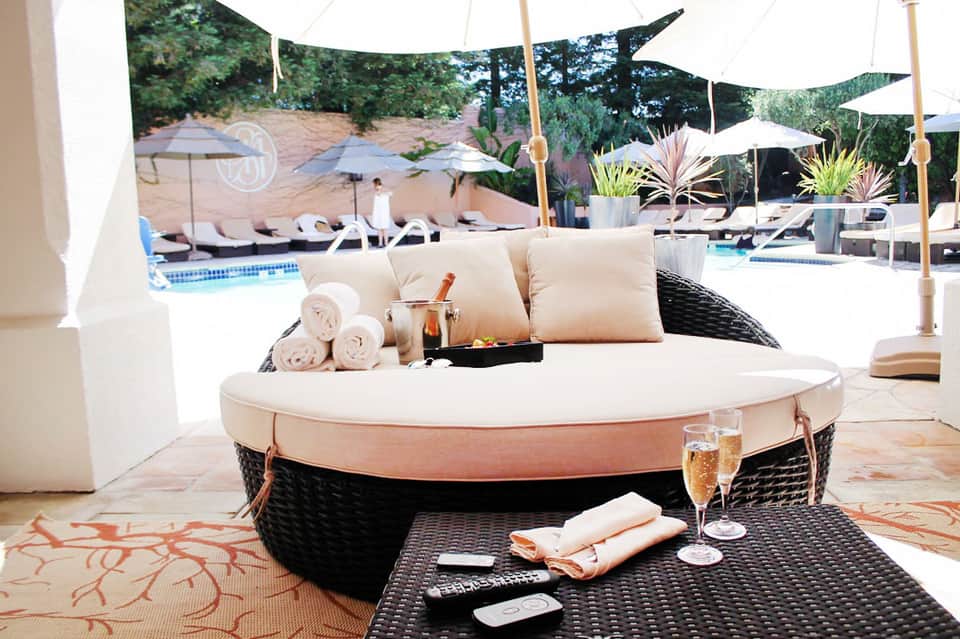 Luxurious round daybed lounge with cream cushions and champagne service at upscale resort pool area