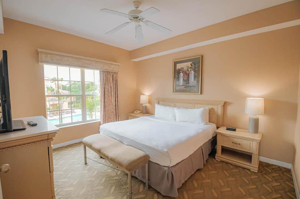 Spacious hotel bedroom with peach walls, queen bed, and ocean view