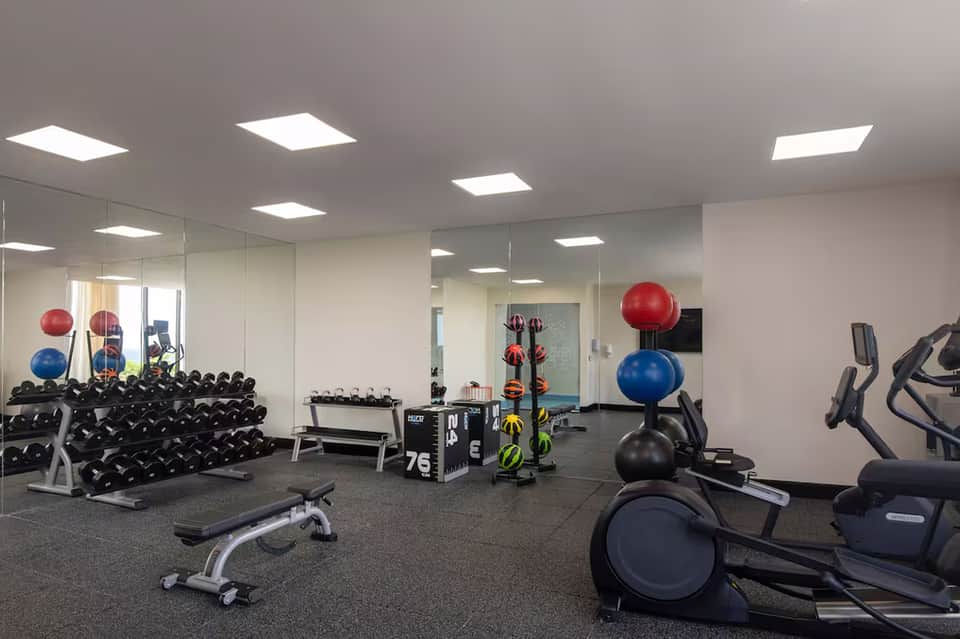 Modern fitness center with dumbbells, exercise balls, and cardio equipment